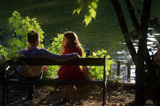 Serene landscape of people relaxing by a tranquil lake at sunset